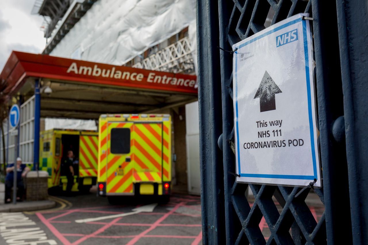 A sign points towards a Coronavirus testing pod as an ambulance arrives at the A&E Department of Kings College Hospital in Camberwell