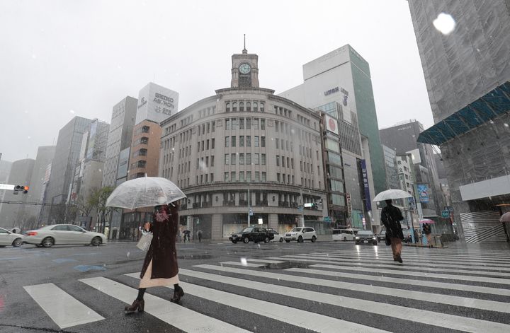 新型コロナウイルスによる外出自粛要請で閑散とした東京・銀座に舞う雪＝3月29日 