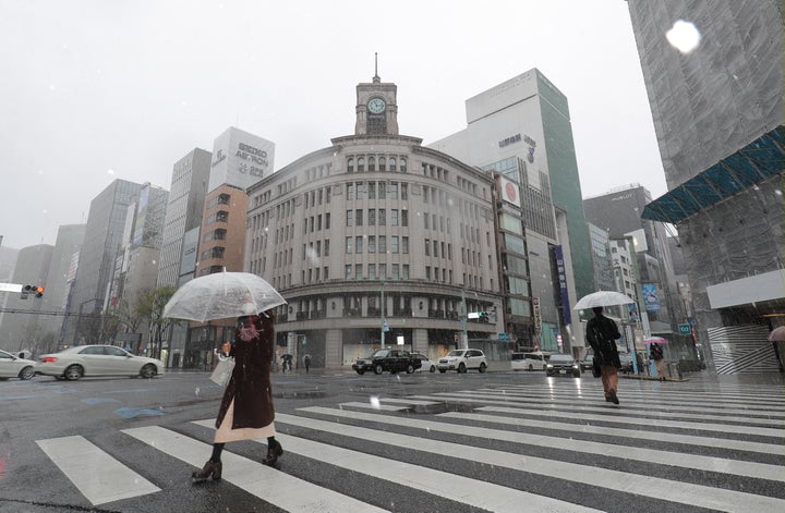 新型コロナウイルスによる外出自粛要請で閑散とした東京・銀座に舞う雪＝3月29日 