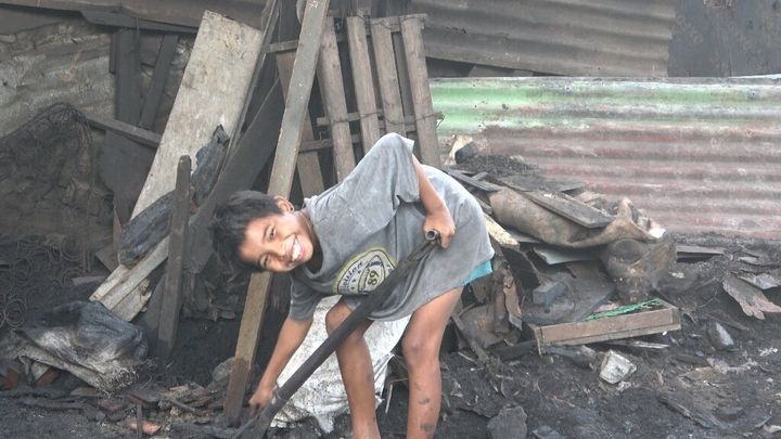 フィリピンの「炭焼き村」で働く少年