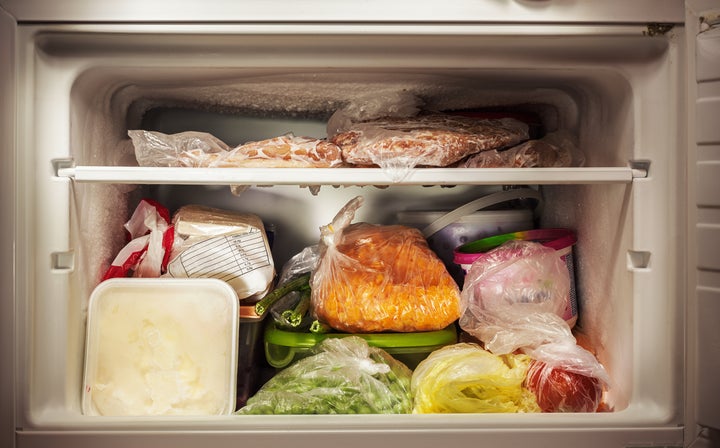 Various frozen food in freezer, illuminated details.