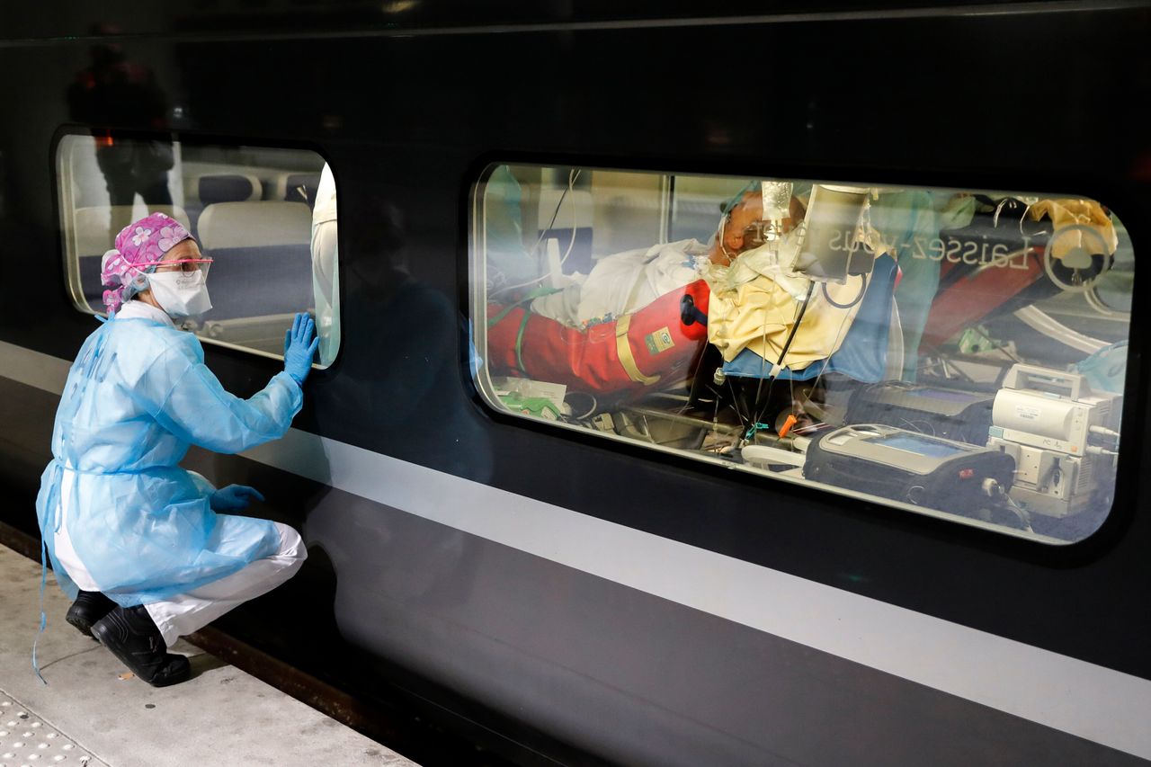 Μέλος ιατρικής ομάδας παρακολουθεί από τον πλατφόρμα σταθμού τρένων συναδέλφους της που παραλαμβάνουν ασθενή με κορονοϊό που ήταν αναίσθητος μέσα σε βαγόνι. (Παρίσι, Γαλλία)