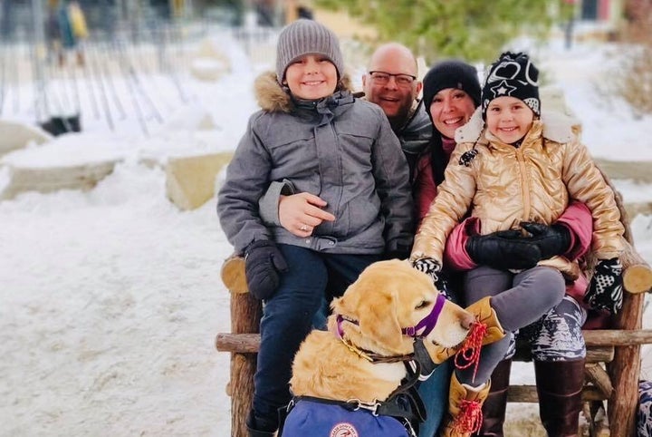 Kat Anderson and family, clockwise from left: daughter Poppy, dad George, mom Kat, son Atlas, and Atlas' service dog.