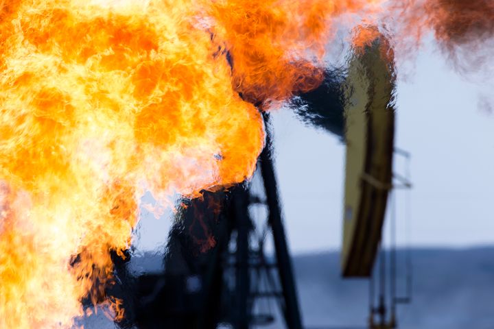A methane gas flare and pump jack at an oil well in the Bakken Oil Fields, North Dakota.