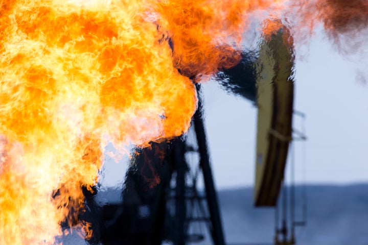 A methane gas flare and pump jack at an oil well in the Bakken Oil Fields, North Dakota.