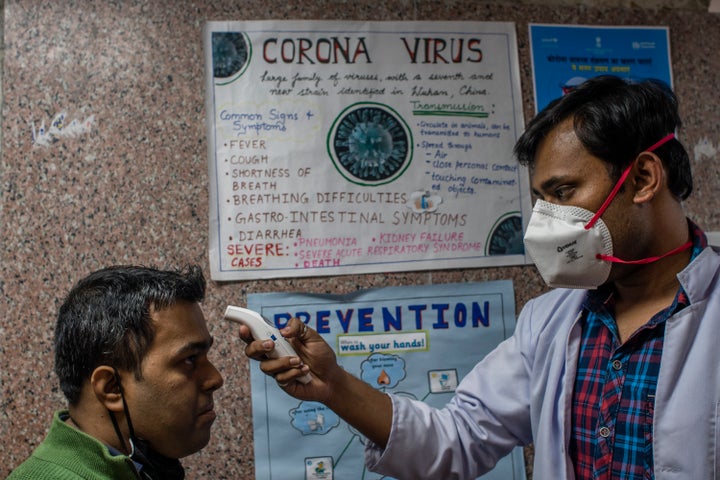 A doctor examines a patient in an area set aside for possible coronavirus cases during a free screening camp at a government homeopathic hospital on March 16, 2020 in New Delhi.