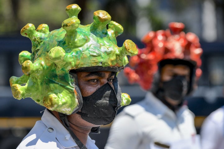 Traffic police personnel wearing coronavirus-themed helmets participate in a campaign to educate the public in Bangalore on March 31, 2020.