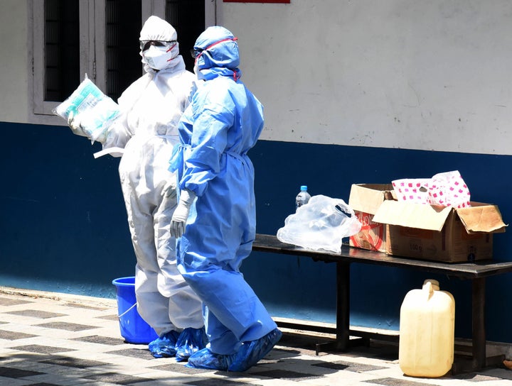 Medical workers wearing protective suits outside a special isolation ward of a Hospital in Kochi, Kerala, March 19, 2020.