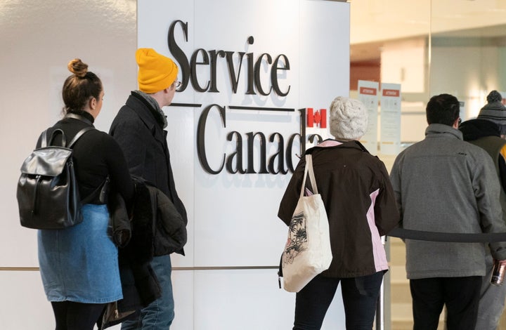 People line up at a Service Canada office in Montreal on Thursday, March 19, 2020.