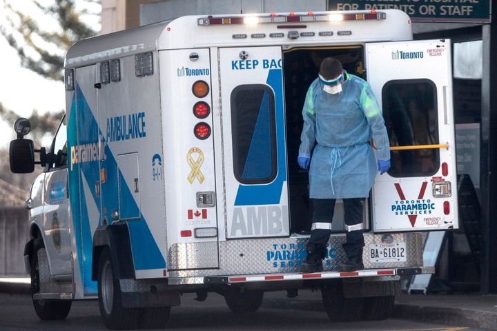 A paramedic stands on the back of an ambulance as a patient is brought into a Toronto hospital, on Wednesday.