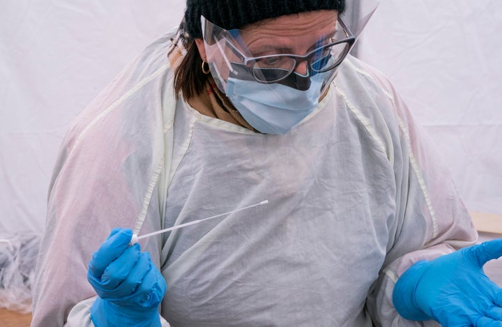 A nurse holds a swab to test a patient at a drive-through clinic at Ste-Justine Children Hospital in Montreal, on Wednesday.