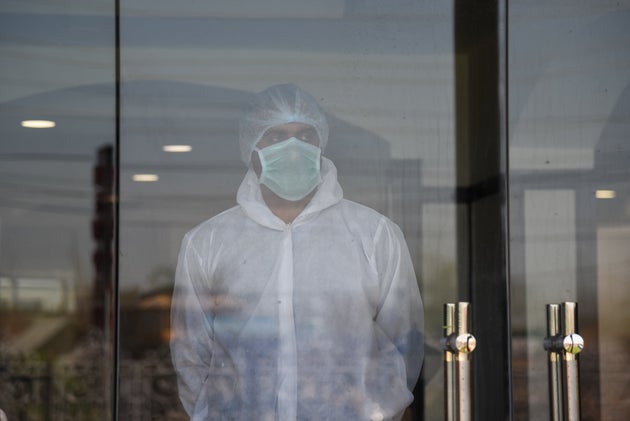 SRINAGAR, JAMMU & KASHMIR, INDIA - 2020/04/04: A medical staff member looks through a window at the...