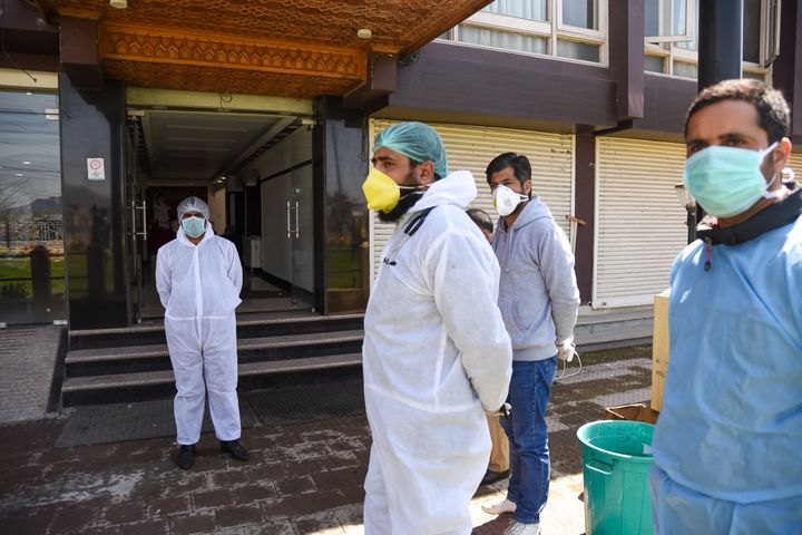 SRINAGAR, JAMMU & KASHMIR, INDIA - 2020/04/04: Medical staff wearing protective gears look on as students studying abroad leave after completing 14 days of Quarantine at a hotel converted Quarantine centre in Srinagar. 