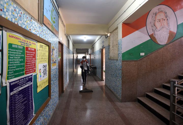 NEW DELHI, INDIA - MARCH 30: A worker cleans the gallery at Sarvodaya Co-Ed Senior Secondary School IP Extension that has been converted by the Delhi Government into a temporary shelter home to accommodate the homeless and migrant workers on day 6 of the 21-day nationwide lockdown imposed by PM Narendra Modi to check the spread of coronavirus, at Patparganj on March 30, 2020 in New Delhi, India. (Photo by Sonu Mehta/Hindustan Times via Getty Images)