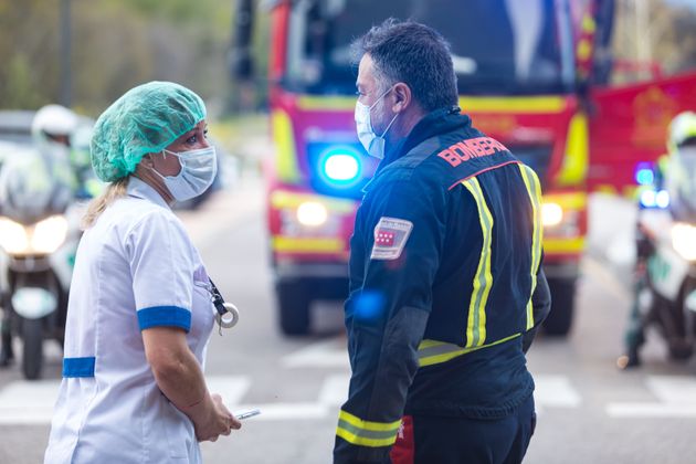 Enfermeira e bombeiro são vistos conversando do lado de fora do Hospital Geral Villalba em 5 de abril de 2020 em Madri, na Espanha.