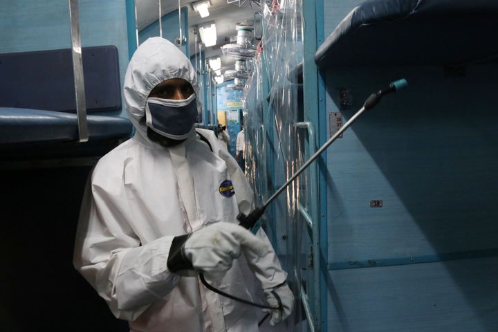 A worker in protective gear sprays disinfectant inside a train carriage converted into an isolation ward for COVID-19 patients during the countrywide 21 day lockdown amid concern over the spread of coronavirus in Howrah.