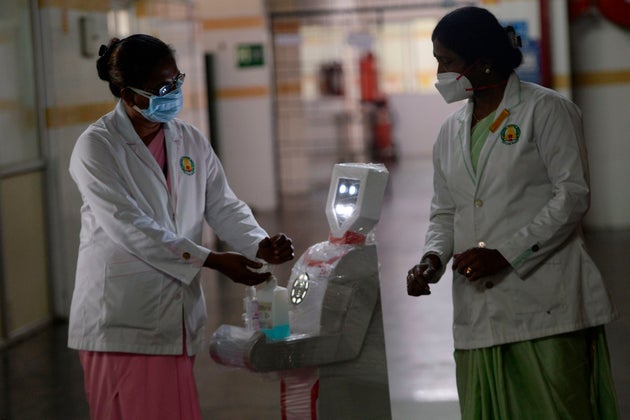 Medical staff participate in a demo of the interactive robot 'Zafi' (C) which will be deployed at Covid...