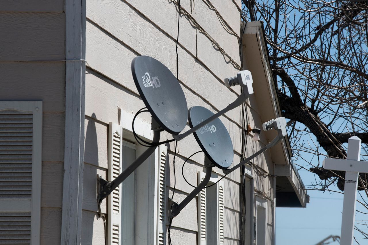 Satellite dishes for TV are shown on the side of a house in Bennett, Colorado. Many Bennett residents rely on satellite internet. But coverage is spotty and expensive.