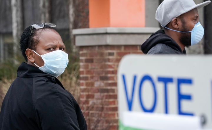 Voters masked against the coronavirus line up at Riverside High School in Milwaukee for Wisconsin's primary election on Tuesday.