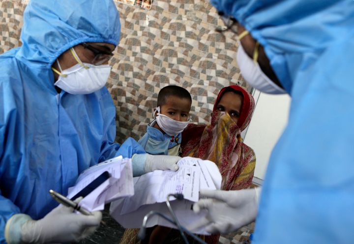 Doctors interact with people at a slum area during lockdown to control the spread of the new coronavirus in Mumbai, India, Tuesday,