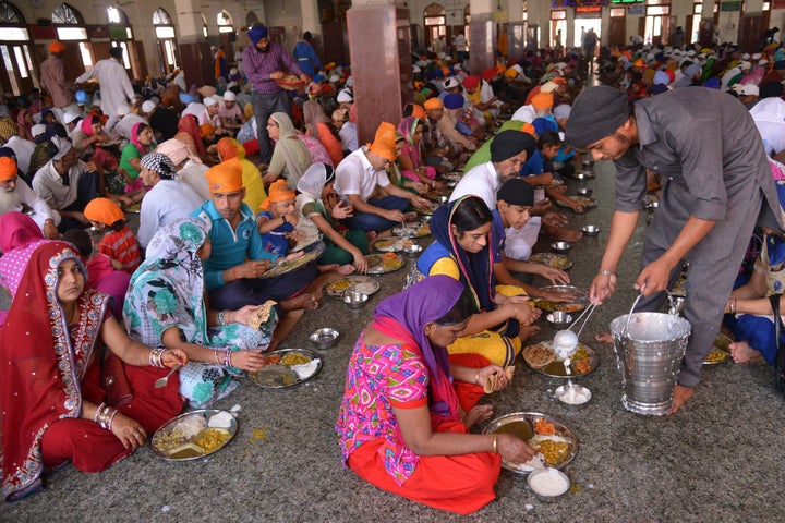 Sikh devotees eat a communal vegetarian meal, known as langar, in a hall at the Golden temple in Amritsar in 2015.