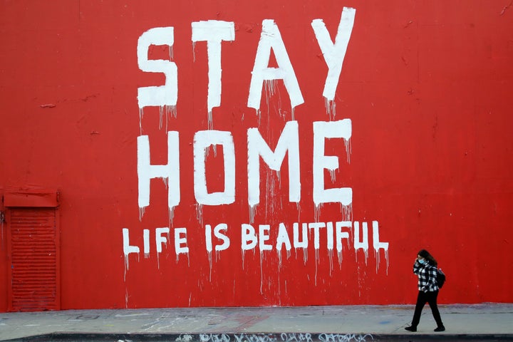 A pedestrian walks past a stay-at-home mural April 2 in Los Angeles, where schools and nonessential businesses are closed and the California governor has ordered people to stay home.