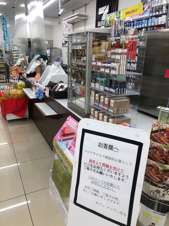 買い物の時も感染リスクはある。感染予防のため、レジにシールドを貼り、飛沫による感染を防ぐコンビニも。床に印をつけてレジ待ちの間隔をあけるよう張り紙が貼り出されていた＝2020年4月6日、東京都内