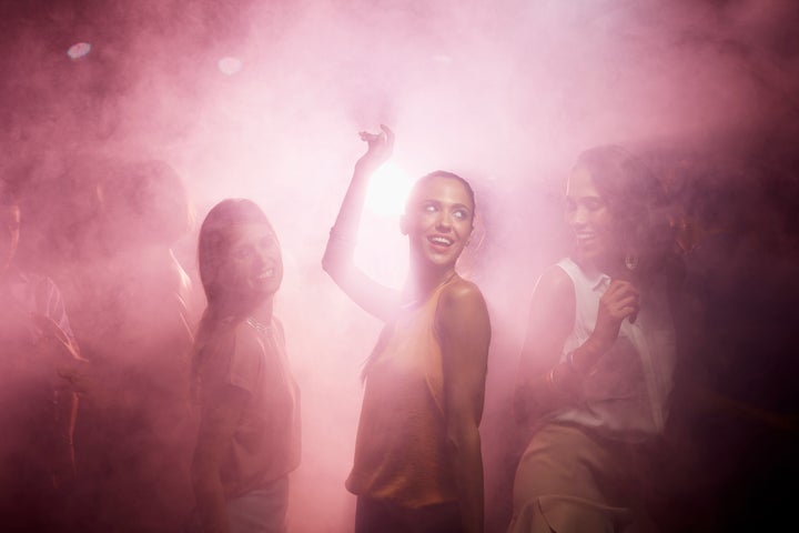 Young female friends enjoying on dance floor at nightclub