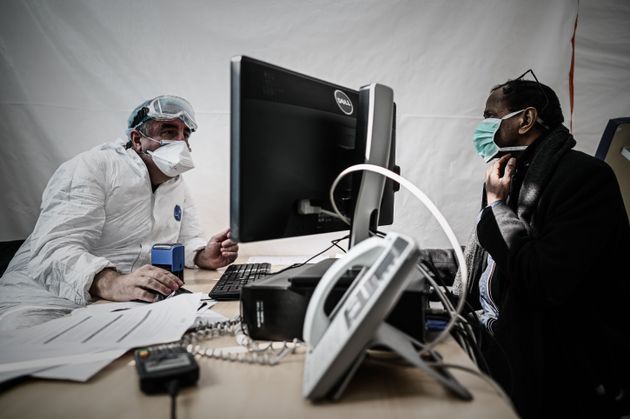 Un médecin d'un centre médical teste un patient afin de détecter le virus COVID-19,...