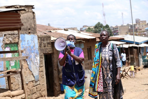 A health volunteer walks through slums in Nairoba, Kenya, informing residents about the coronavirus pandemic....