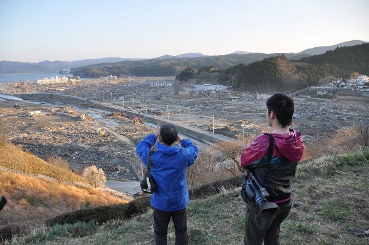 高台から流された街を見る牧さんと川口さん＝2011年4月16日、宮城県南三陸町