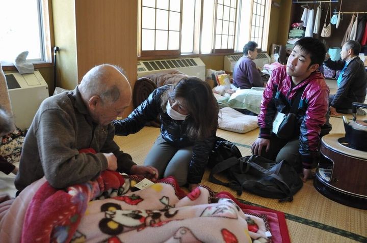 梶田さんは老夫婦の話に涙を浮かべ、時折背中をさすり話を聞いていた＝宮城県石巻市の避難所