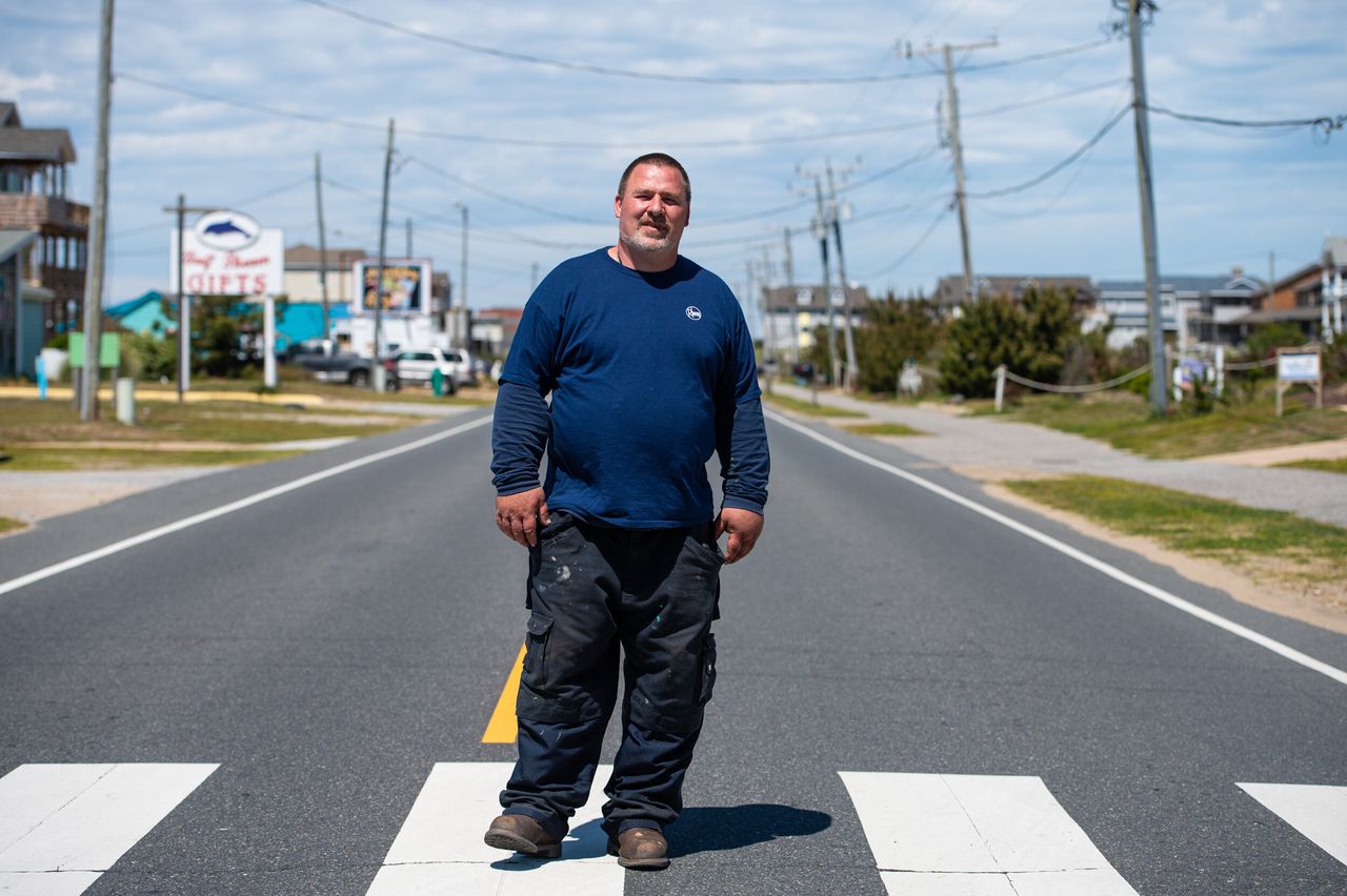 Joseph Bakersmith, a Dare County resident, plumber and newly dubbed "essential worker," poses on a deserted "beach road" (South Virginia Dare Trail) in Nags Head, North Carolina.