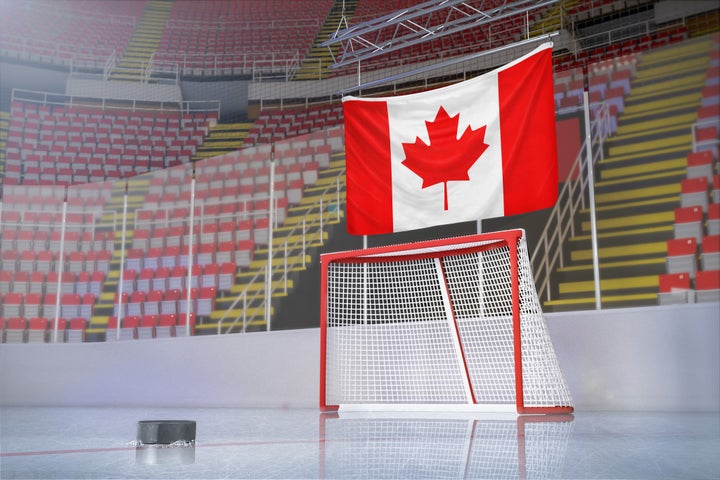 In this stock photo, an empty hockey arena is seen with a Canadian flag hanging in the bleachers. It may be a long time before anyone sees an NHL game in person, a new report on the impact of COVID-19 on Canada says.