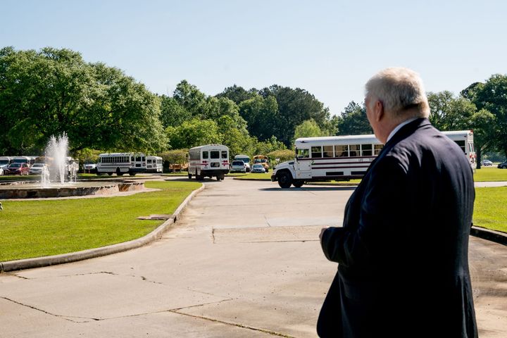 Joe Long, an attorney working with Pastor Tony Spell, watches as buses bring congregation members to Life Tabernacle Church f