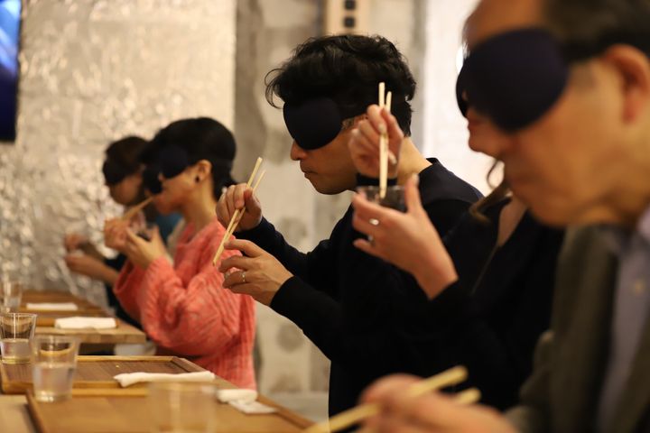 アイマスクを着けてごはんを食べる参加者たち