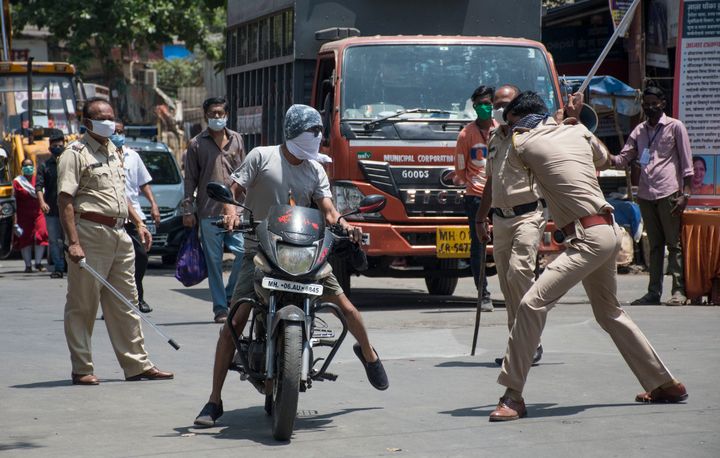 Police officials punish people who came out during the lockdown at Bhandup, Mumbai on April 4, 2020.