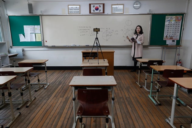 Teacher Chung Ha-eun gives an online class amid the new coronavirus outbreak at Seoul girls' high school in Seoul, Thursday, April 9, 2020. Senior high school students begin school semester with online classes.  Schools remain closed as part of measures taken by the government to stop the spread of the coronavirus. (AP Photo/Ahn Young-joon)
