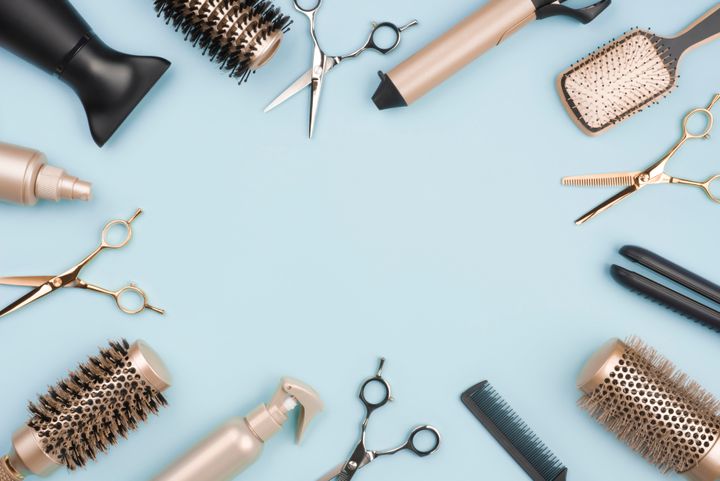 Hair cutting tools and accessories on blue background with space