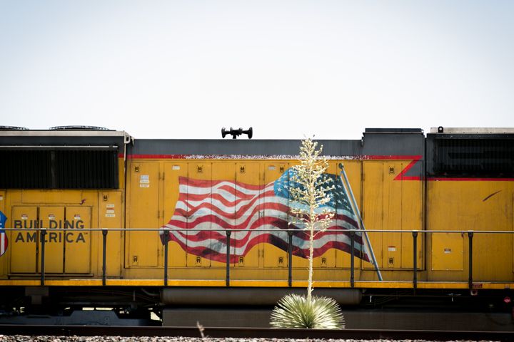 Agave plant in front of a yellow/gold freight train engine.