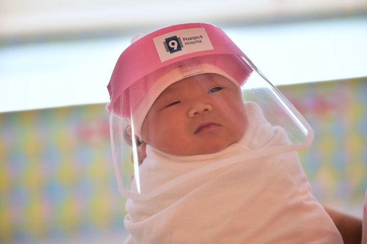 A newborn baby wearing a face shield at a hospital in Bangkok.