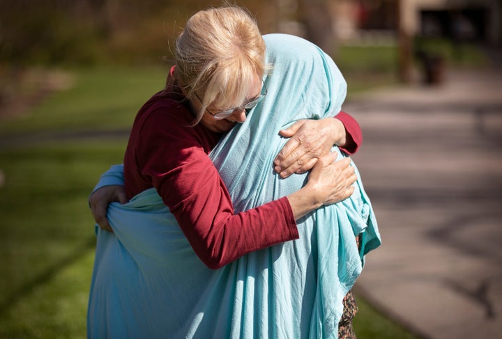 Cheryl Norton, of Blue Ash, Ohio, gives her ICU nurse daughter a spontaneous hug by putting a sheet over her.