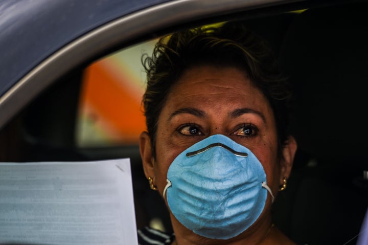 People wait in their cars as they line up outside John F. Kennedy Library to collect unemployment forms in Hialeah, Florida, on April 8, 2020. The city is distributing printed forms as people are having trouble accessing the state of Florida’s unemployment website.