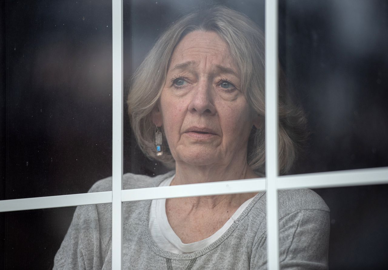Linda Beaupre gazes out a window of her home on Wednesday. She lost her husband of 35 years to COVID-19.