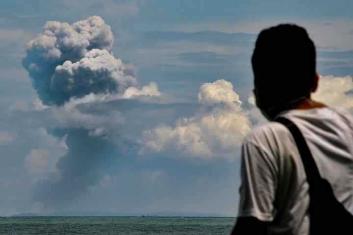 A man watches Krakatau spewing ash during an eruption, in Serang, Indonesia's Banten province on April 11, 2020. (Photo by RONALD SIAGIAN / AFP) (Photo by RONALD SIAGIAN/AFP via Getty Images)