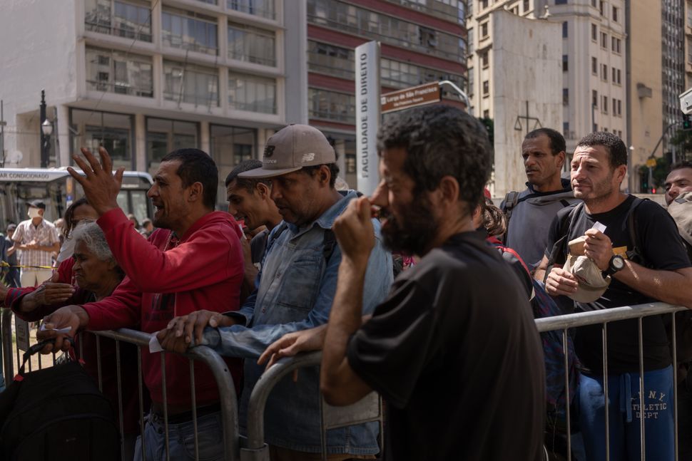 Homeless people queue for food at a medical screening center in São Paulo.