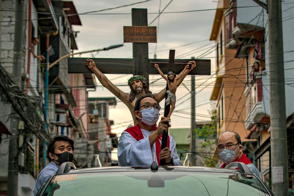 10일 필리핀 마닐라의 한 거리에서 예수상을 든 신부가 트럭을 타고 이동제한령이 내려진 주거지를 돌고 있다. 필리핀은 인구의 대부분이 천주교 신자인 것으로 유명한 나라지만 올해만큼은...