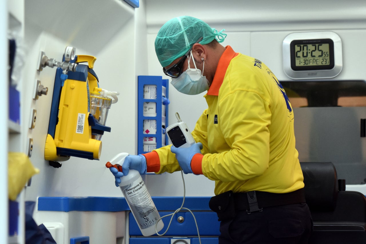 A health technician from the Catalan Emergency Medical Service disinfects an ambulance after transporting a suspected Covid-19 patient 