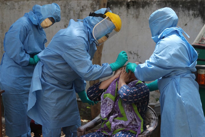 A medical team conducts a swab test at an urban health centre during lockdown in Ahmedabad, April 10, 2020.