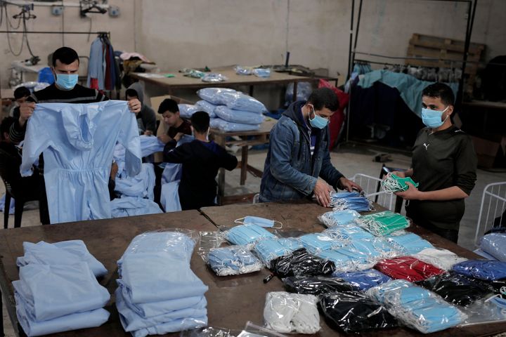 Palestinian workers manufacture protective coverall suits and masks at a workshop in Gaza City on April 12, 2020. amid coronavirus COVID-19 pandemic. (Photo by Majdi Fathi/NurPhoto via Getty Images)